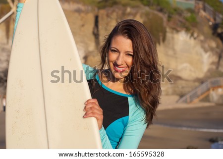 Beautiful surfer girl - Closeup of beautiful young surfer girl holding her surfboard.