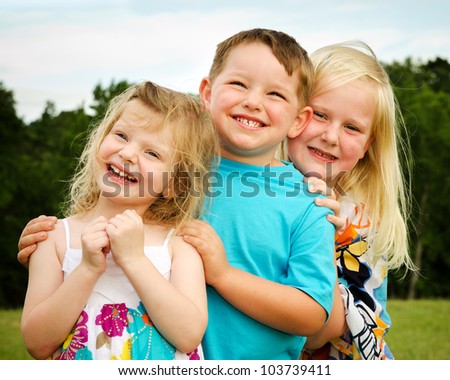 Portrait of three children playing at park