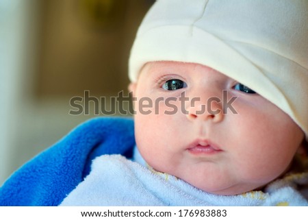 Close up portrait of infant baby boy bundled up after a bath.