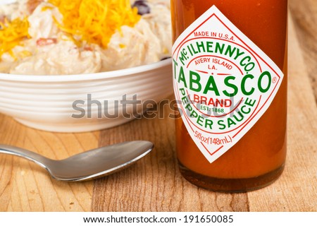 ATLANTA - MAY 8, 2014: Bottle of Tabasco brand hot pepper sauce next to a bowl of white chicken chili.