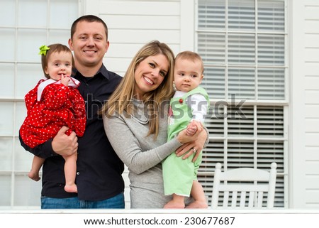 Portrait of family with twin babies at home on front porch