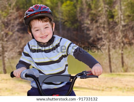 Boy riding bike with safety helmet outdoors at park