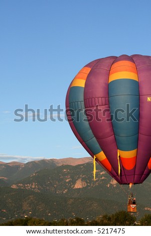 Early morning hot air balloon with Colorado Rockies as backdrop
