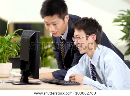 Two people discuss problems in front of a computer
