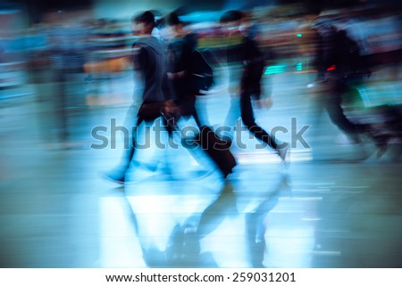 abstract blur of passengers rushing at big city station.