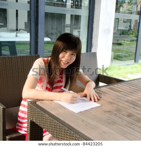 asian woman on desk with paper outdoor