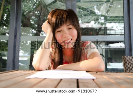 smile asian woman on desk with paper outdoor