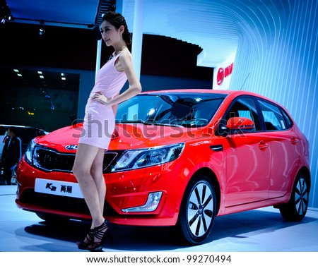 GUANGZHOU, CHINA - NOV 26: unidentified model with KIA K2 car at the 9th China international automobile exhibition. on November 26, 2011 in Guangzhou China.