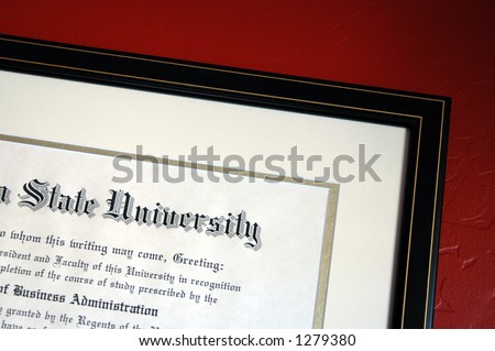 University Degree framed and hanging on textured red wall.