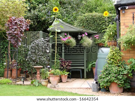 English back garden Patio area in Summer with Gazebo hanging baskets and Sunflowers
