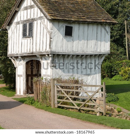Historic Medieval Gatehouse over a Moat in Rural England next to a five bar gate and driveway