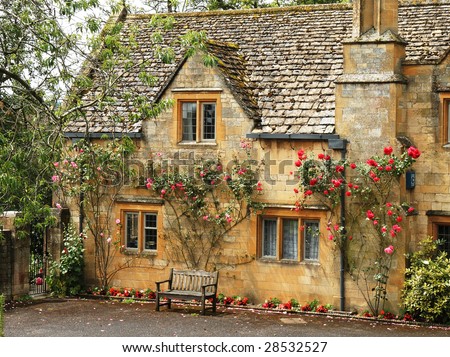 Traditional Stone English Village House covered in climbing Roses