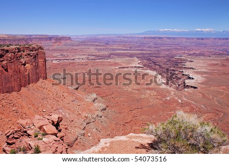 Red Rocks and boulders in Canyon Land Utah in the USA with snow capped mountains in the far distance