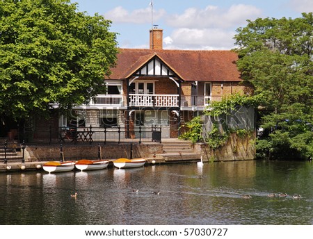House on the River Thames in England with moored boats
