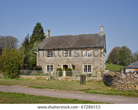 Traditional English Rural Manor Farmhouse set behind a fence and gate