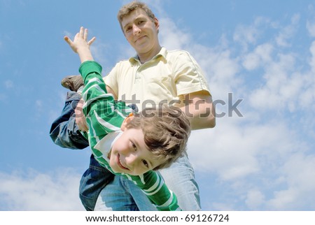 Father and son against the blue sky with clouds