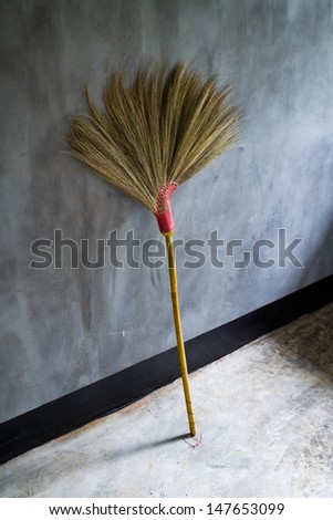 Old broom or besom on the gray wall