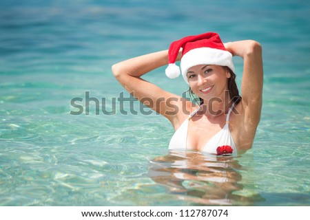 Happy santa woman on the beach. Christmas vacation