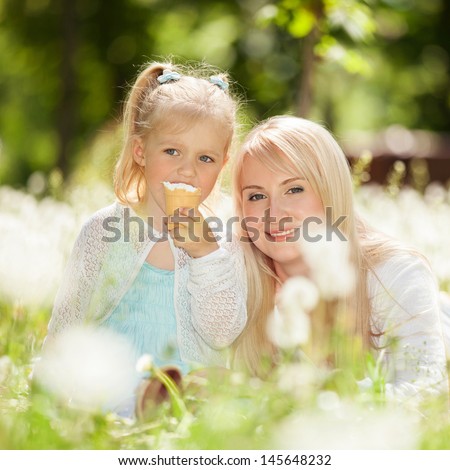Mother and daughter eating ice-cream in the park