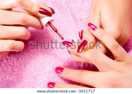Young woman with beautiful long nails make the manicure