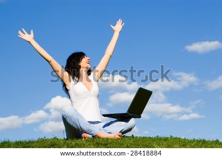 pretty woman with laptop on the green grass