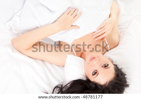 Cute woman sleeps on the white bed