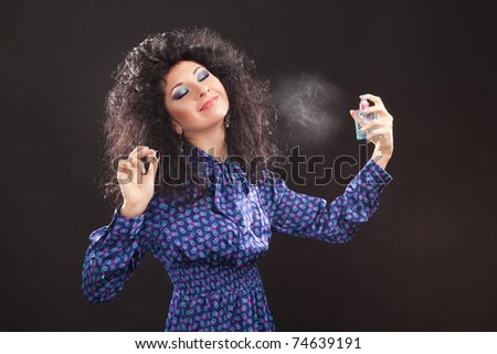 Young fashion woman with perfume on black background