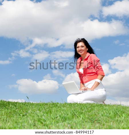 Cute woman with white laptop in the park