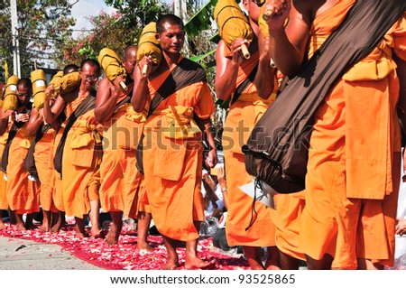 BANGKOK,THAILAND-JAN 21:Row of Buddhist hike monks on streets strewn with rose petals on the Thammachai hike establish the path of the great teachers,On Jan 21,2011 in Bangkok