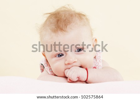 Baby girl lying and looking into the camera and posing. Expressing positivity.