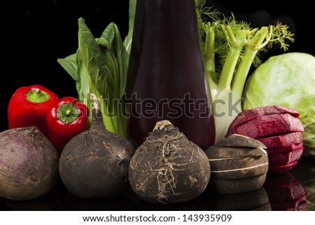 Fresh organic vegetable still life. Black radish, purple eggplant, capsicum, fennel, cabbage and chinese cabbage isolated on black background. Colorful vegetarian and vegan healthy eating variation.