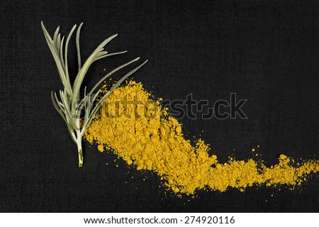 Curry spice and curry plant isolated on black background, top view. Aromatic spice background.