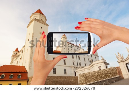 Bratislava castle tourism. Female tourist taking picture of Bratislava castle on smartphone. Tourism concept.