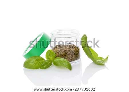 Fresh basil herb and dry basil spice in glass jar isolated on white background. Culinary healthy aromatic herbs. Culinary arts.