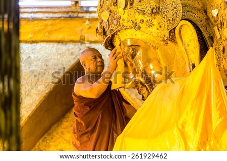 MANDALAY - FEB 19: The senior monk wash Mahamuni Buddha image in ritual of the Buddha image face wash on February 19, 2015 at Mahamuni temple in Mandalay, Myanmar.This ritual commences every morning