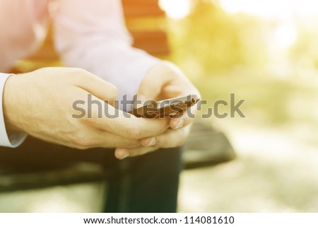 smartphone in hand, blurred background