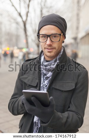 Young man reading messages and information using an i-pad tablet computer.