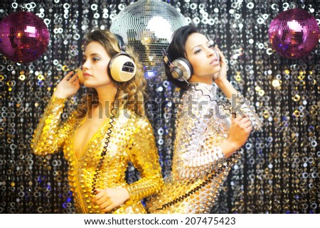 two beautiful sexy disco women in gold and silver catsuits dancing in a club setting. Useful for fashion, beauty, music and events