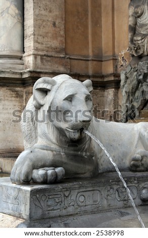 lion statue spitting water at fountain in rome
