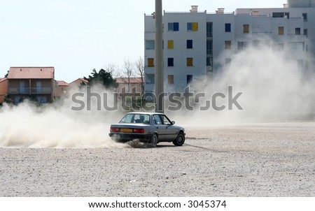 a car skidding in a carpark making lots of dust