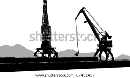 Silhouettes of two port cranes background of sand