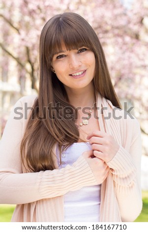 Positive young woman posing in pink cardigan sweater