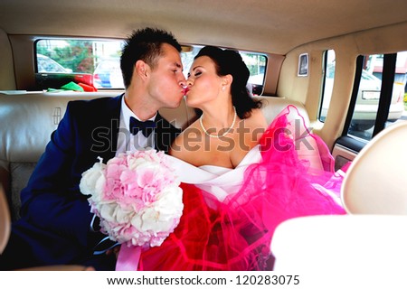 wedding couple hugging and kissing in a private moment of joy in car