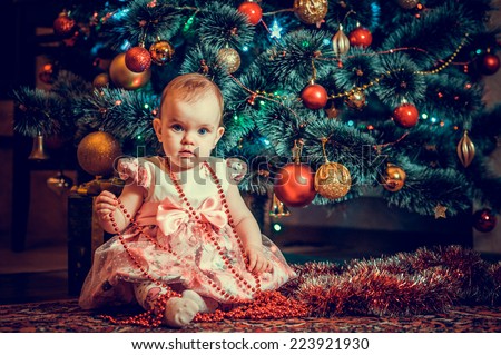 Little girl being happy about christmas tree and lights. little princess