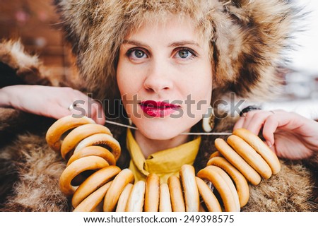 Winter Girl in Luxury Fur Coat and hat with bagels. Fashion Fur