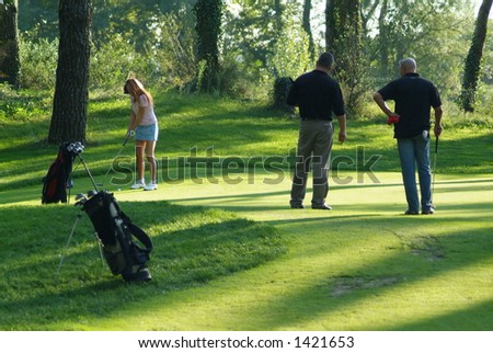 a group of golfer a girl and two men watching over her