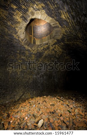 Old ventilation shaft and rubble in Tunnel Underground Light painting in disused railway tunnels, darkness creatively lit with torches.