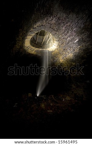Falling water, Dark Tunnel ventilation shaft. Underground Light painting in disused railway tunnels, darkness creatively lit with torches.