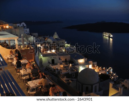 view of nicely lit restaurant with big liner and island on the sea in background