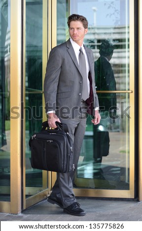 Handsome Business Man Leaving Building through Revolving Doors